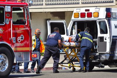 paramedics taking an injured person into an ambulance