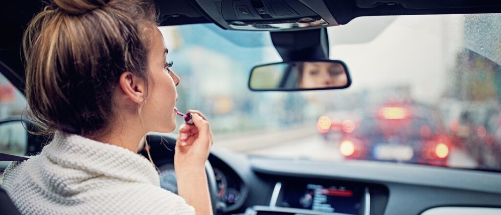 bad driving habits cause auto accidents, woman putting makeup on while driving